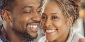 Casal sorrindo, abraçando carinhosamente.