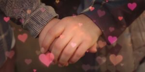 Casal de mãos dadas, corações coloridos, amor.